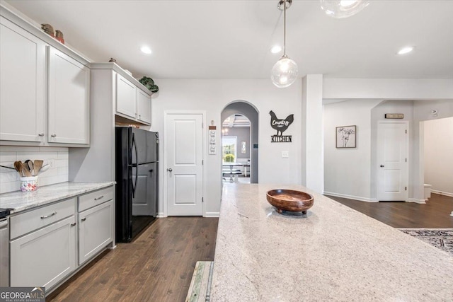 5321 Felles Way, Forsyth, GA 31029 - kitchen featuring freestanding refrigerator, arched walkways, dark wood finished floors, tasteful backsplash, and recessed lighting