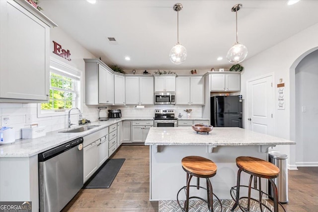 5321 Felles Way, Forsyth, GA 31029 - kitchen with stainless steel appliances, arched walkways, backsplash, a breakfast bar, and recessed lighting