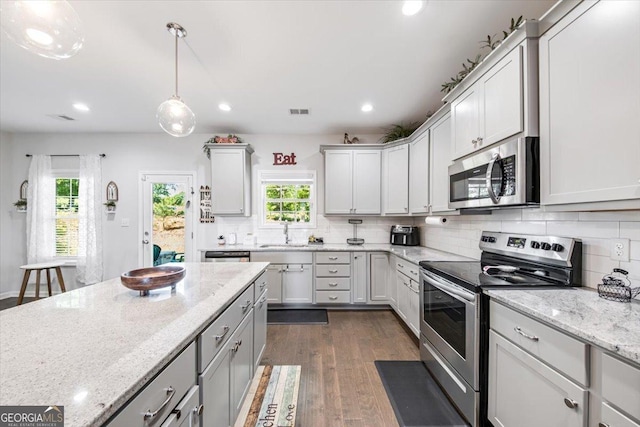 5321 Felles Way, Forsyth, GA 31029 - kitchen with appliances with stainless steel finishes, tasteful backsplash, recessed lighting, dark wood-style flooring, and hanging light fixtures