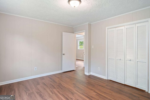 2125 Perkerson Mill Rd, Austell, GA 30106 - unfurnished bedroom with a closet, dark wood-style floors, a textured ceiling, and crown molding