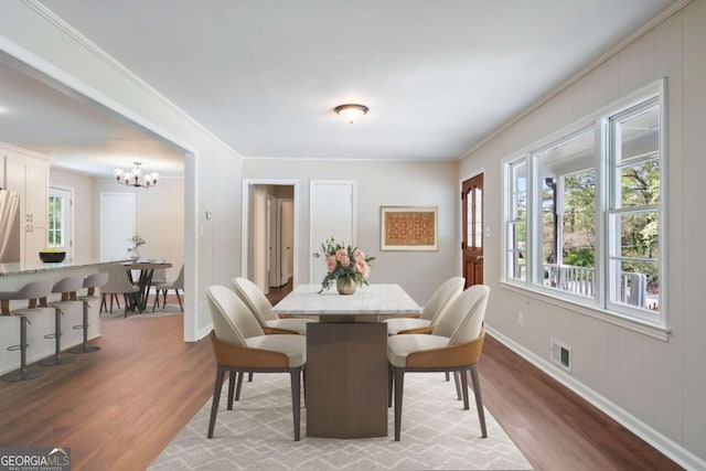 2125 Perkerson Mill Rd, Austell, GA 30106 - dining space featuring baseboards, ornamental molding, a chandelier, visible vents, and wood finished floors