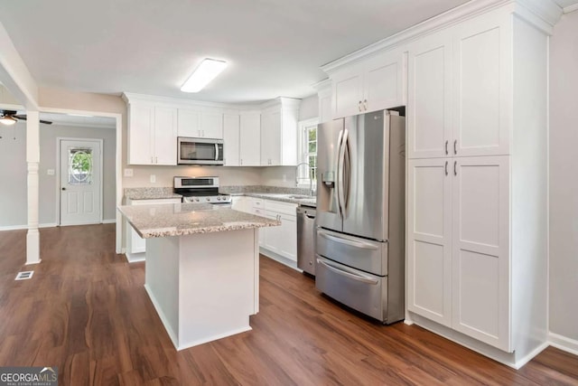 2125 Perkerson Mill Rd, Austell, GA 30106 - kitchen featuring stainless steel appliances, a sink, white cabinets, a center island, and dark wood-style floors
