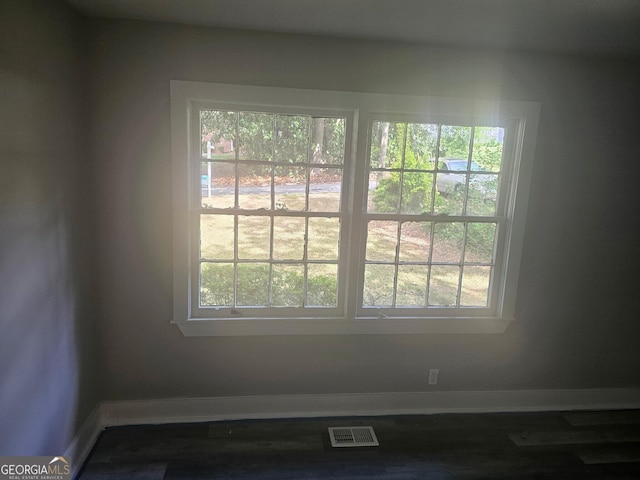 room details with baseboards, wood finished floors, and visible vents
