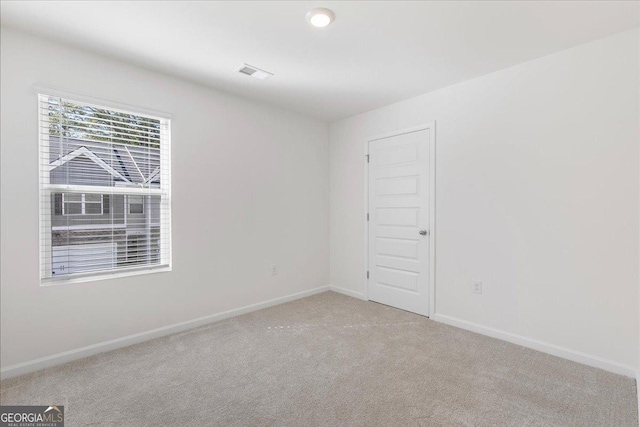 unfurnished room featuring carpet, visible vents, and baseboards