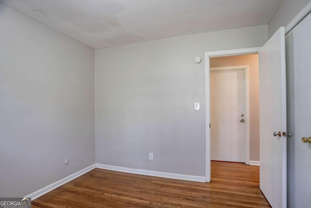 empty room featuring wood finished floors and baseboards