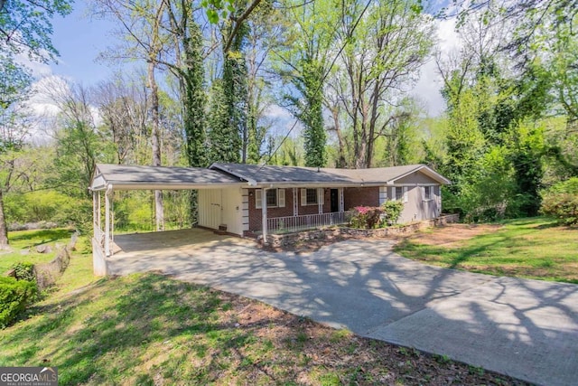 ranch-style home featuring a front yard, a porch, an attached carport, and driveway