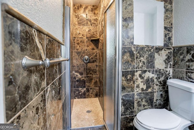 full bathroom featuring toilet, a stall shower, and tile walls