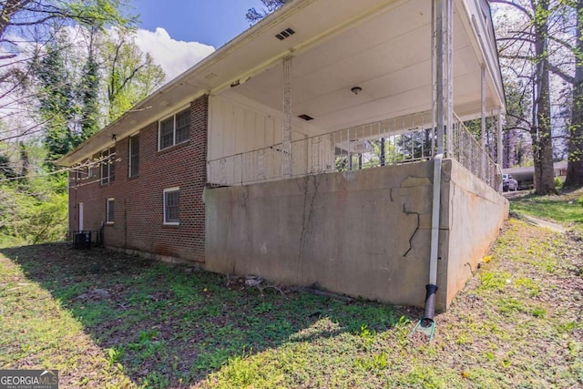 view of side of property with brick siding and cooling unit