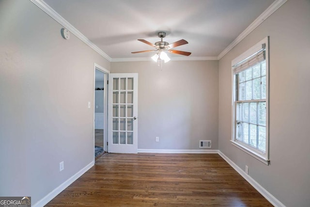 spare room with a healthy amount of sunlight, ceiling fan, dark wood finished floors, and visible vents