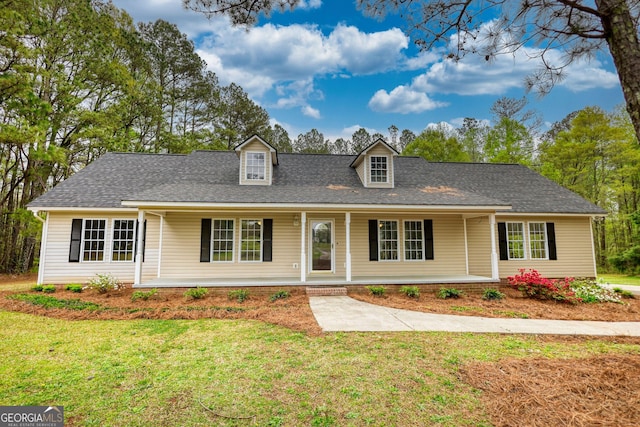 view of front facade featuring a porch, roof with shingles, and a front lawn