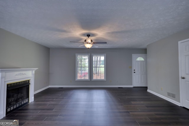 unfurnished living room featuring dark wood-style flooring, baseboards, a fireplace, visible vents, and ceiling fan