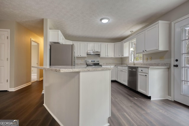 kitchen featuring white cabinetry, under cabinet range hood, dark wood-style floors, and stainless steel appliances