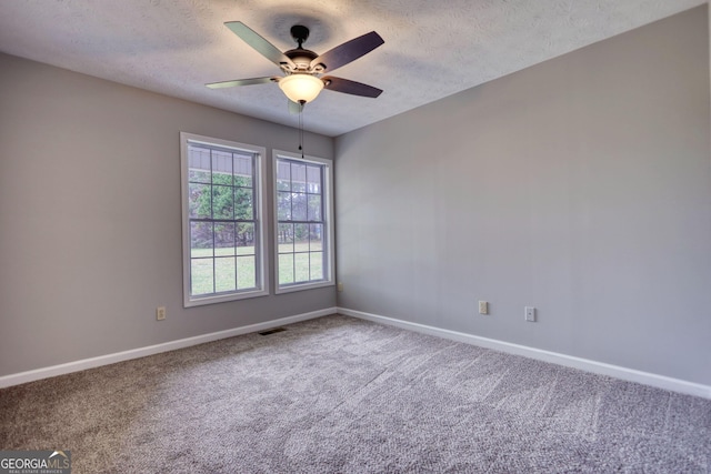 carpeted empty room featuring visible vents, baseboards, a textured ceiling, and ceiling fan