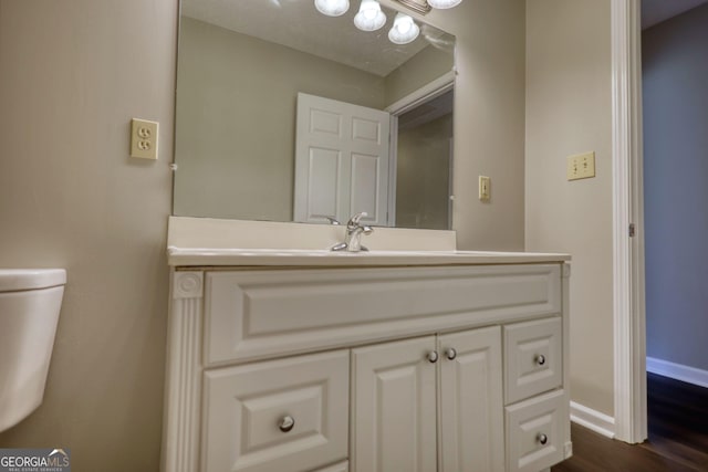 bathroom with vanity, baseboards, and wood finished floors
