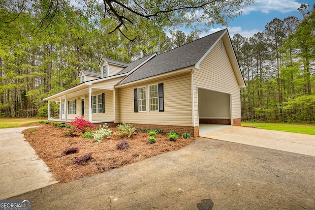view of property exterior featuring a shingled roof, a garage, and driveway