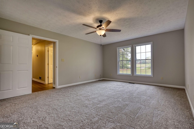 unfurnished room with dark colored carpet, baseboards, a textured ceiling, and ceiling fan