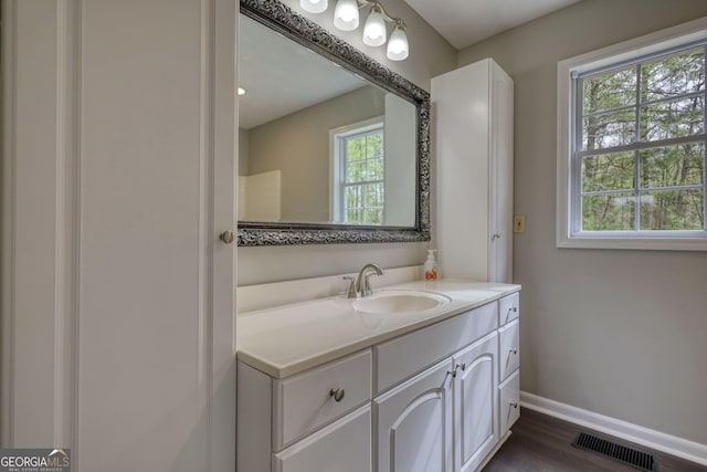 bathroom featuring visible vents, baseboards, vanity, and wood finished floors