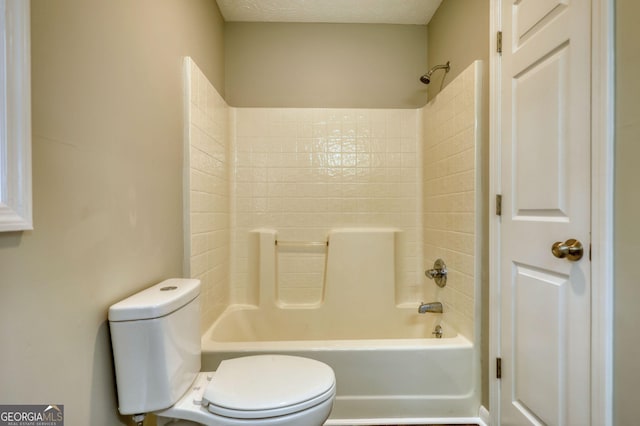 bathroom with toilet, a textured ceiling, and shower / tub combination