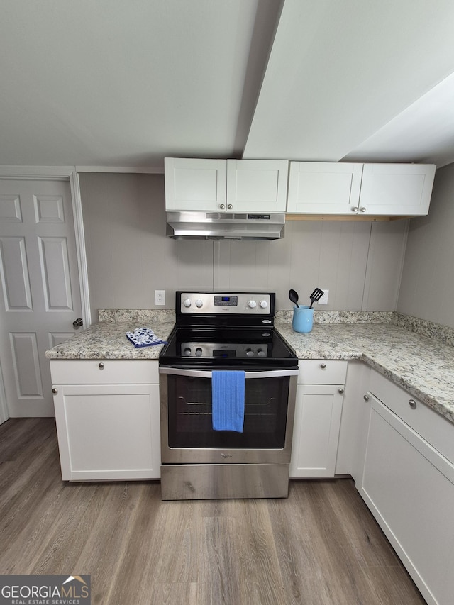 kitchen with white cabinets, stainless steel electric stove, wood finished floors, and under cabinet range hood