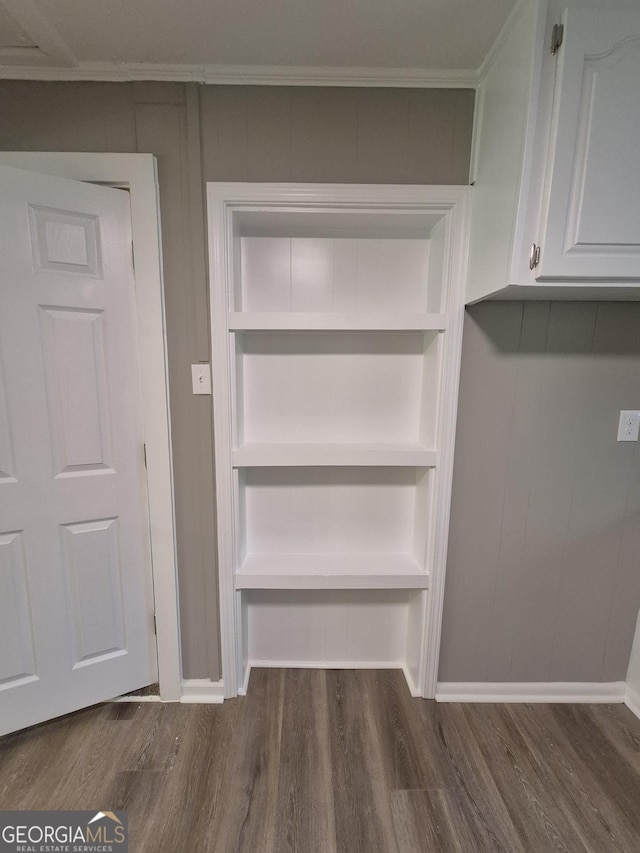 room details with crown molding, built in features, baseboards, and wood finished floors