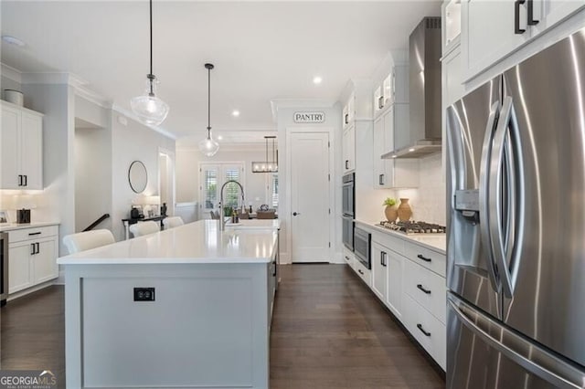 825 Maplewood Dr, Roswell, GA 30075 - kitchen featuring light countertops, appliances with stainless steel finishes, wall chimney exhaust hood, and a center island with sink