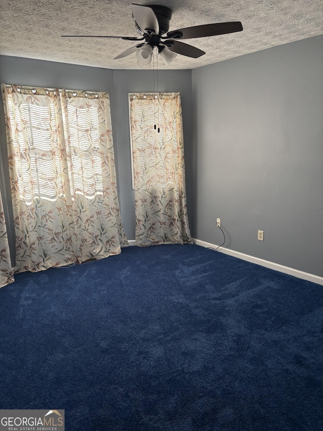 carpeted empty room with ceiling fan, baseboards, and a textured ceiling