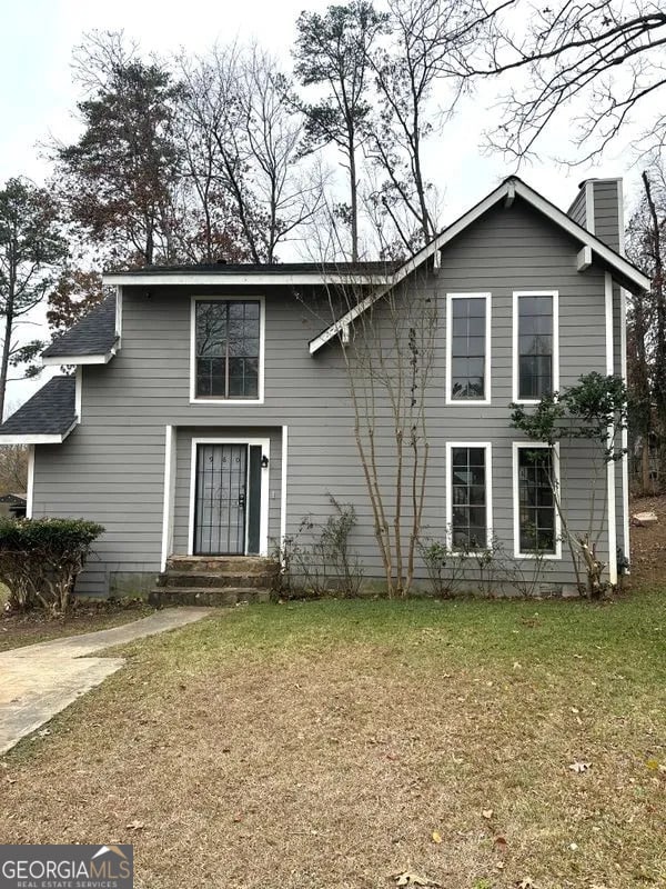 view of front of home with a front lawn and a chimney