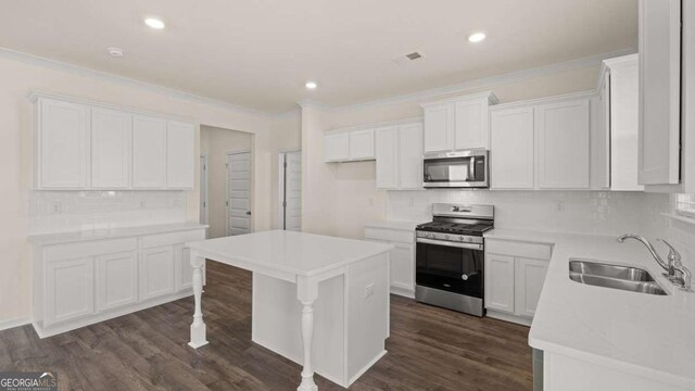 1139 Blue Juniper Cir, Loganville, GA 30052 - kitchen featuring crown molding, visible vents, dark wood finished floors, stainless steel appliances, and a sink