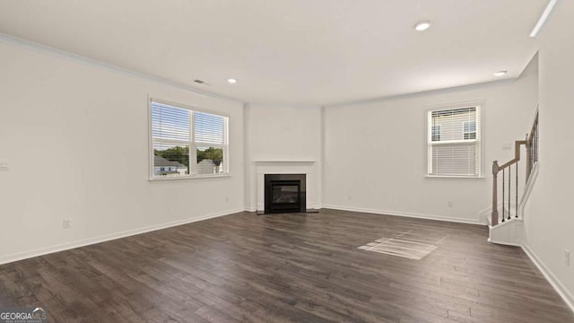 1139 Blue Juniper Cir, Loganville, GA 30052 - unfurnished living room featuring a glass covered fireplace, baseboards, recessed lighting, stairway, and dark wood-style floors