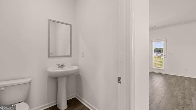 1139 Blue Juniper Cir, Loganville, GA 30052 - half bath featuring baseboards, a sink, toilet, and wood finished floors
