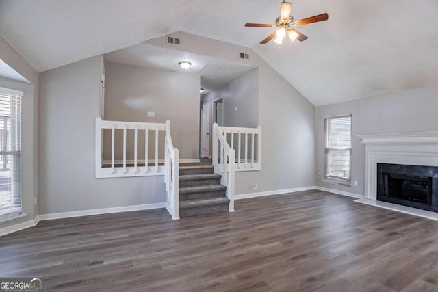 unfurnished living room featuring wood finished floors, visible vents, baseboards, and vaulted ceiling