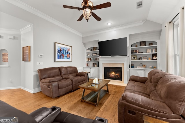 6058 Grand Reunion Dr, Hoschton, GA 30548 - living room featuring crown molding, light wood-style flooring, a glass covered fireplace, a ceiling fan, and visible vents