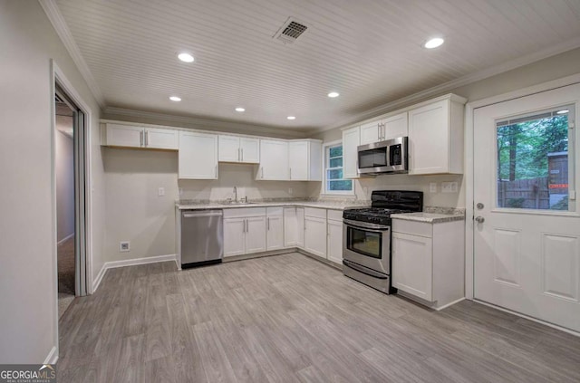 3647 Miller St, Lithia Springs, GA 30122 - kitchen featuring stainless steel appliances, a sink, white cabinets, light wood-style floors, and ornamental molding