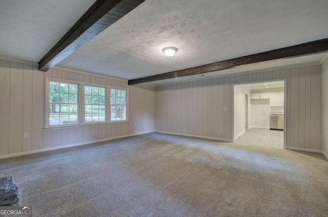 3647 Miller St, Lithia Springs, GA 30122 - spare room featuring beamed ceiling, a textured ceiling, carpet, wood walls, and baseboards