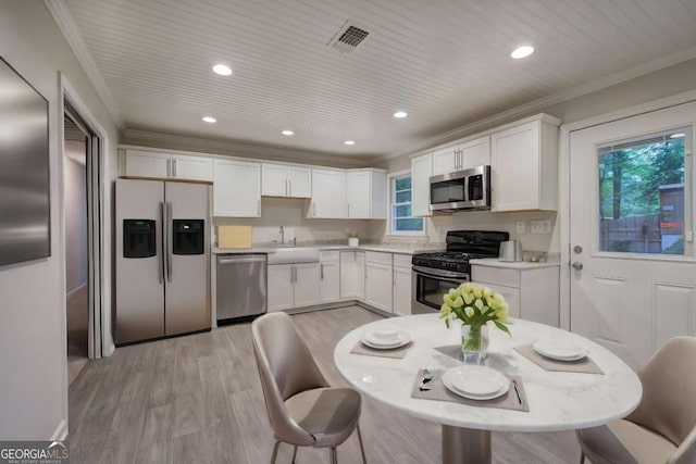 3647 Miller St, Lithia Springs, GA 30122 - kitchen with stainless steel appliances, light wood finished floors, light countertops, white cabinetry, and recessed lighting