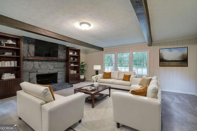3647 Miller St, Lithia Springs, GA 30122 - carpeted living room featuring beamed ceiling, a textured ceiling, a stone fireplace, baseboards, and built in shelves