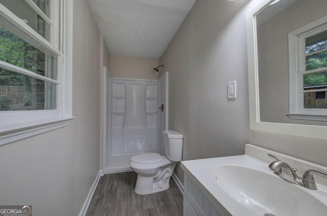 3647 Miller St, Lithia Springs, GA 30122 - bathroom featuring a shower, wood finished floors, toilet, vanity, and a textured ceiling