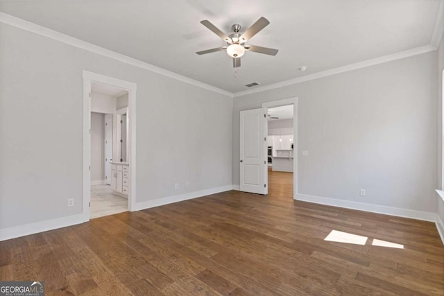 unfurnished bedroom featuring crown molding, visible vents, baseboards, and wood finished floors