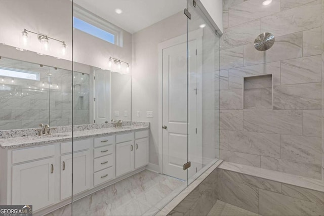 bathroom with a sink, a shower stall, marble finish floor, and double vanity