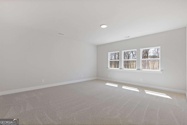 spare room featuring visible vents, baseboards, and carpet flooring