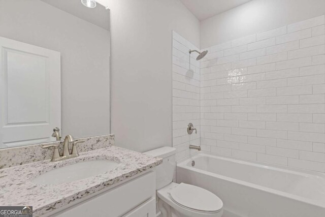 bathroom featuring washtub / shower combination, vanity, and toilet