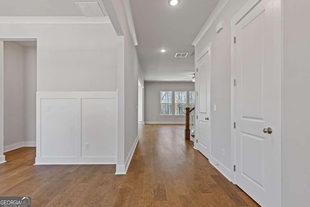hall featuring crown molding, wood finished floors, visible vents, and recessed lighting