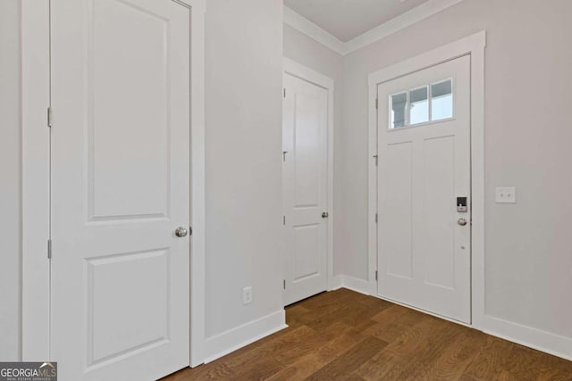 entryway with ornamental molding, baseboards, and dark wood finished floors