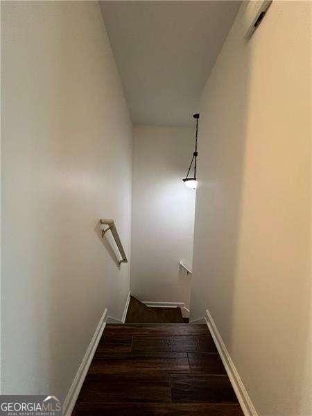 stairs with wood finished floors and baseboards