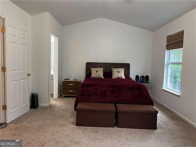 bedroom featuring carpet floors, baseboards, connected bathroom, and vaulted ceiling