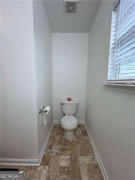 bathroom featuring visible vents, baseboards, and toilet