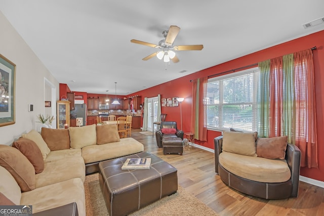 living area featuring light wood-style flooring, ceiling fan, baseboards, and visible vents