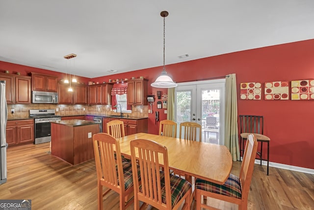 dining area with visible vents, french doors, and light wood-style floors
