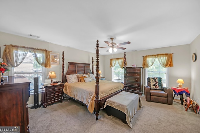 carpeted bedroom with visible vents and a ceiling fan