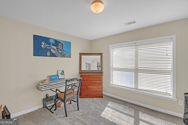 office area featuring a healthy amount of sunlight, visible vents, baseboards, and carpet